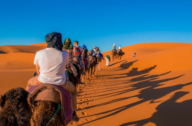 Foto de personas paseando en camellos por Marruecos