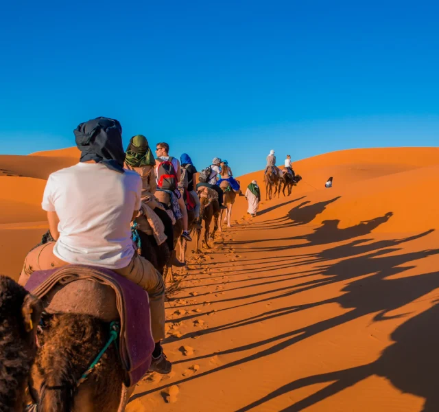 Foto de personas paseando en camellos por Marruecos